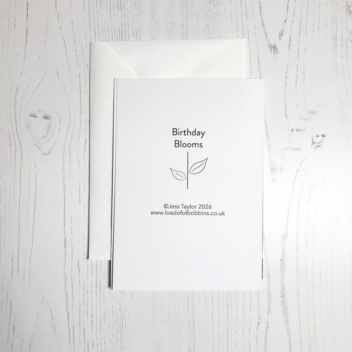 The back of an A6 greetings card which has printed details on the back saying Birthday Blooms copyright Jess Taylor 2026 www.loadofolbobbins.co.uk