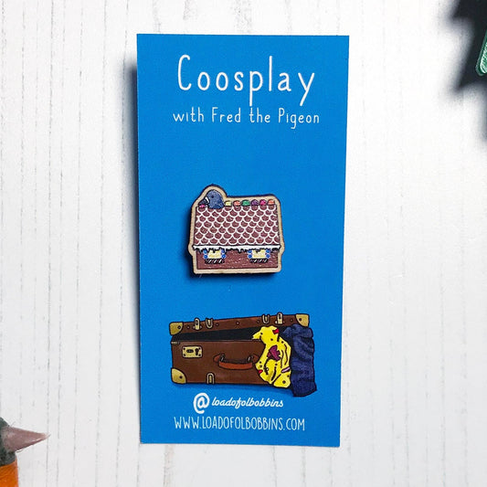 A laser cut wooden mini lapel pin showing an original illustration by Loadofolbobbins of a pigeon with it's head popping out of a gingerbread house nibbling on some jelly sweets. The style of the illustration is simplified with flat colours and a bold black outline. The pin is mounted on a blue backing card that says Coosplay with Fred the pigeon.