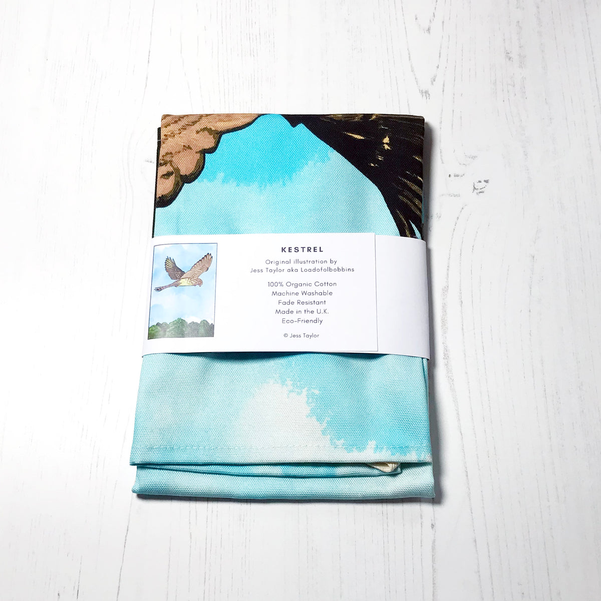 Text on a belly band around a folded tea towels they say kestrel. Original llustration by Jess Taylor aka Loadofolbobbins. 100% organic cotton, machine washable, fade resistant,made in the UK, Eco friendly. Copyright Jess Taylor.