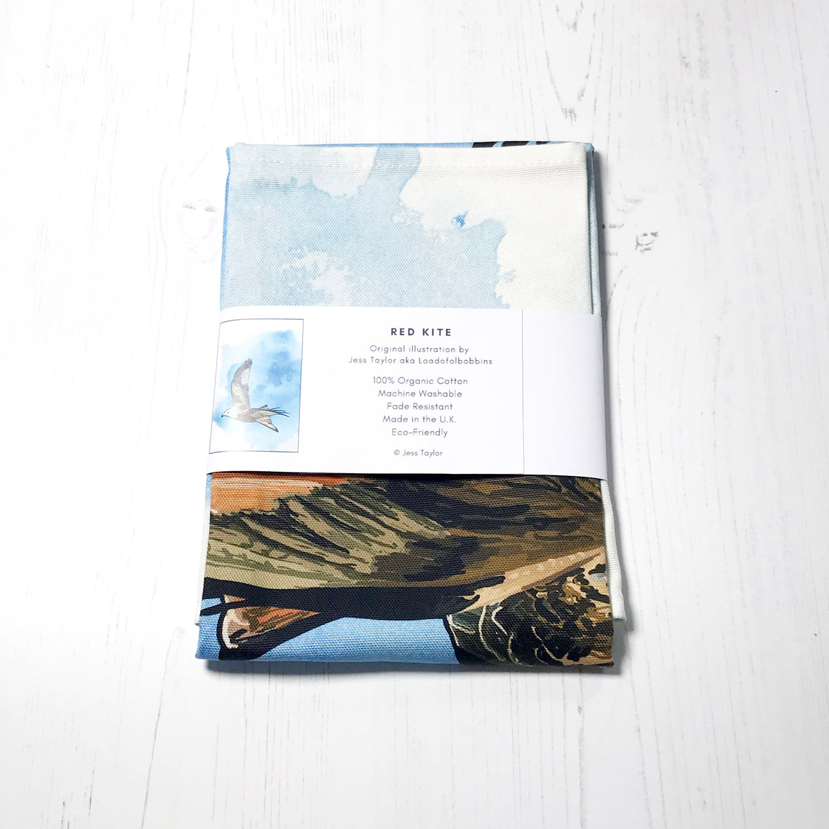 Text on a belly band around a folded tea towels they say Red kite. Original llustration by Jess Taylor aka Loadofolbobbins. 100% organic cotton, machine washable, fade resistant,made in the UK, Eco friendly. Copyright Jess Taylor.