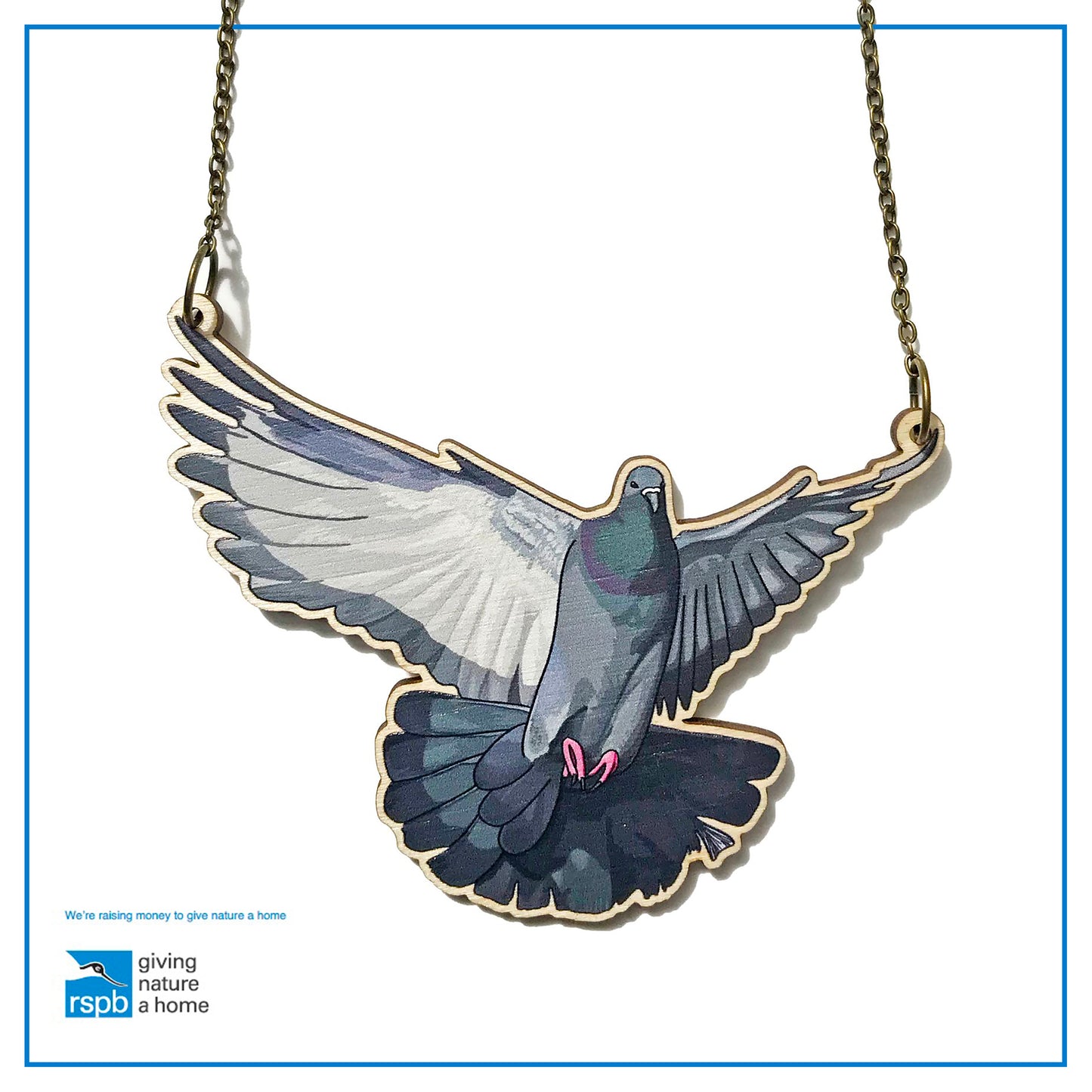 A laser cut wooden charm necklace showing an illustration of a flying pigeon with wings outstretched by loadofolbobbins. The wooden necklace is hanging from an antique bronze cable chain.